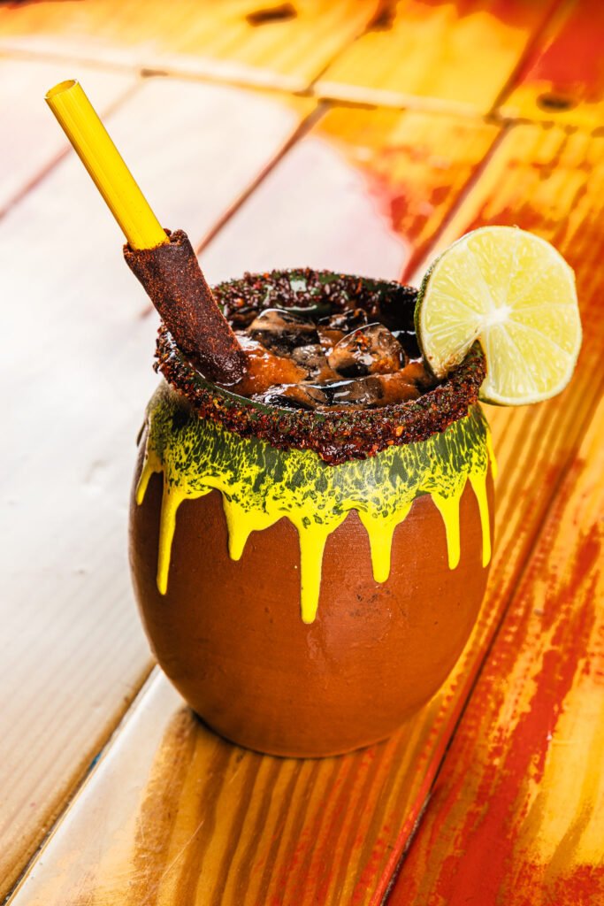 Clay cantarito cocktail with chamoy rim, lime and tamarind straw, drink photography for a Mexican restaurant