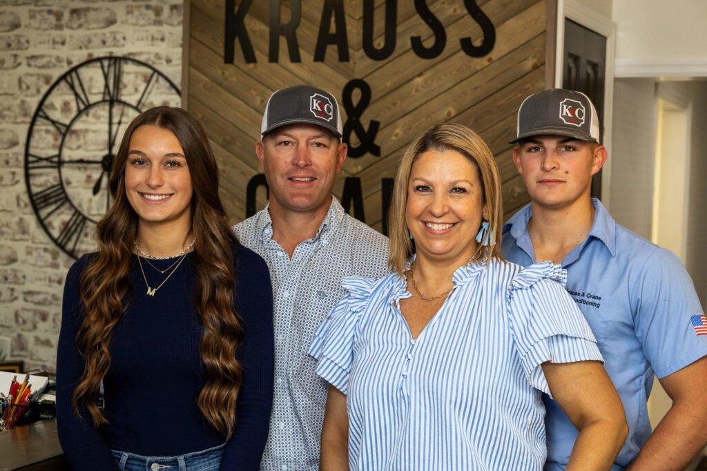 Corporate branding portrait of a family business team in front of their company logo wall