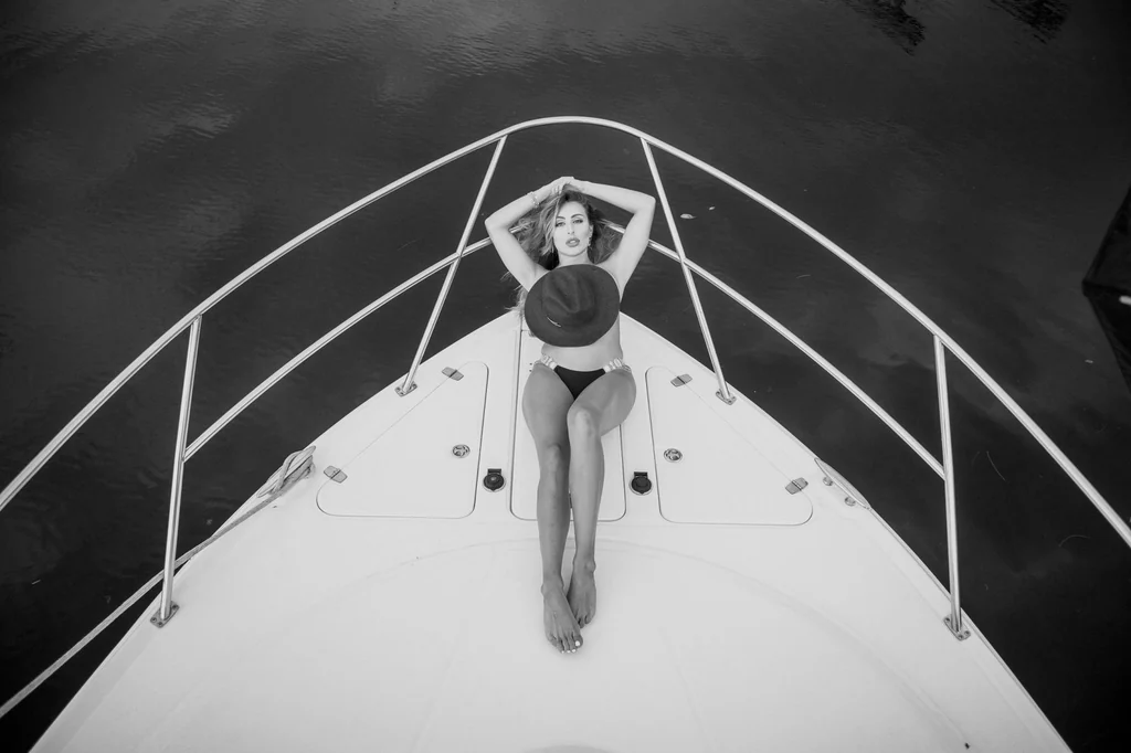 Black and white swimwear editorial of a model lying on the bow of a yacht in Miami, photographed by Felipe Restrepo