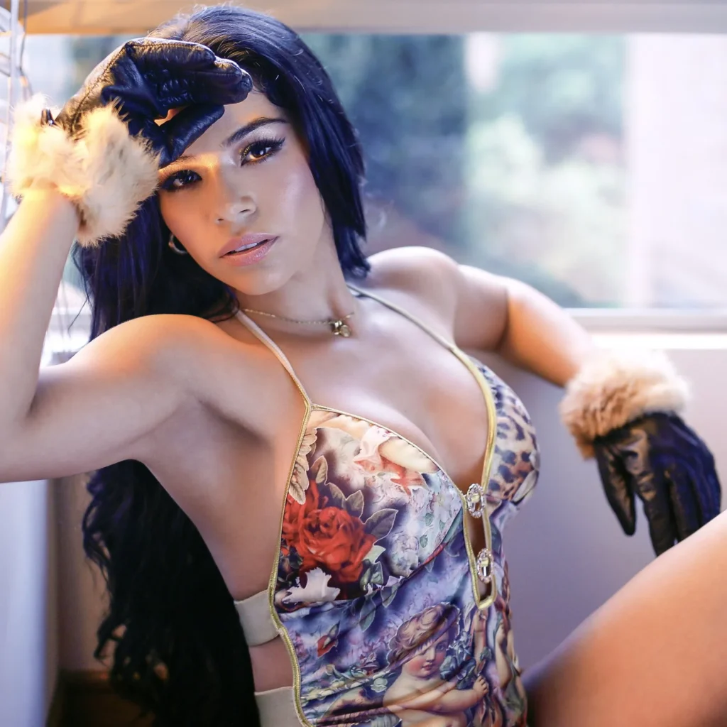 Woman with dark hair in a floral bodysuit and fur shrug posing on a sofa, glamour portrait — boudoir photography in Palm Beach and Miami by Felipe Restrepo