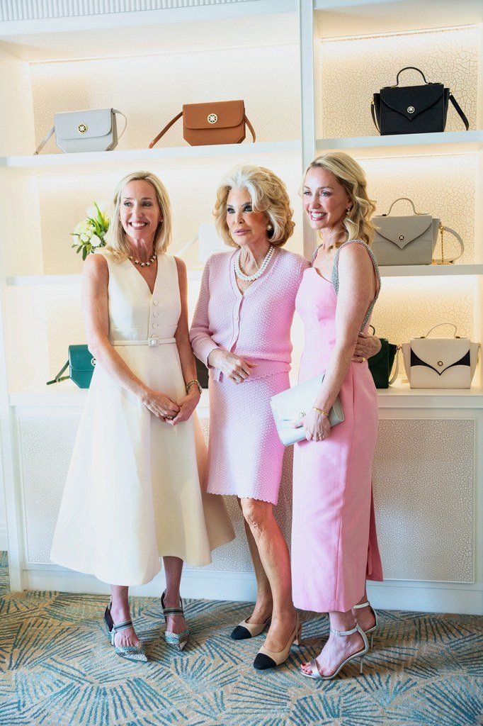 Three elegantly dressed women at a luxury handbag boutique event in Palm Beach