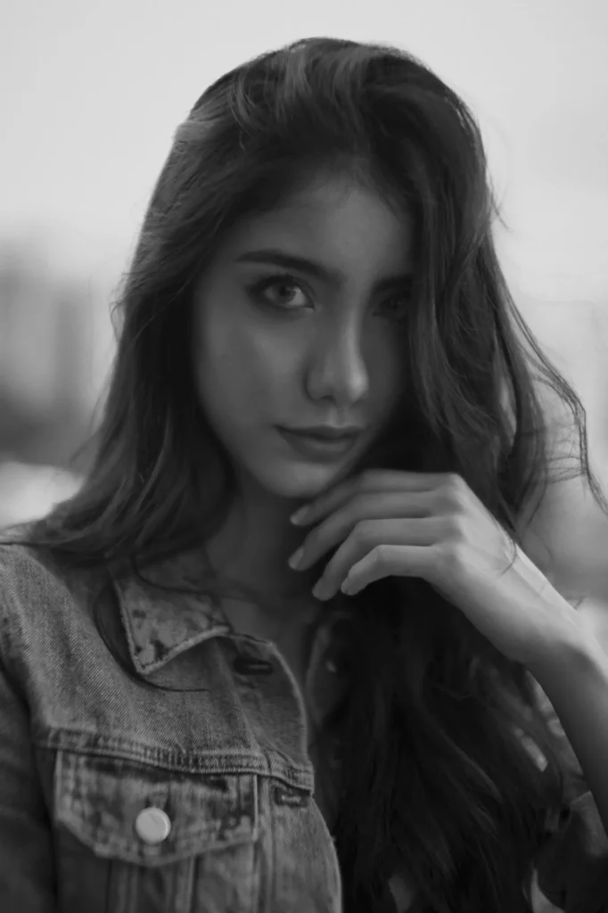 Black and white boudoir portrait of a woman in a denim jacket touching her face — boudoir photography in Palm Beach and Miami by Felipe Restrepo