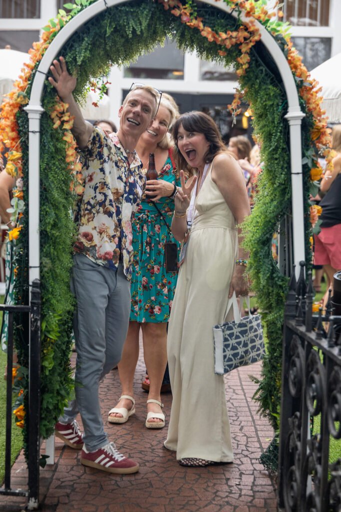 Group photo in front of a floral arch at a corporate event