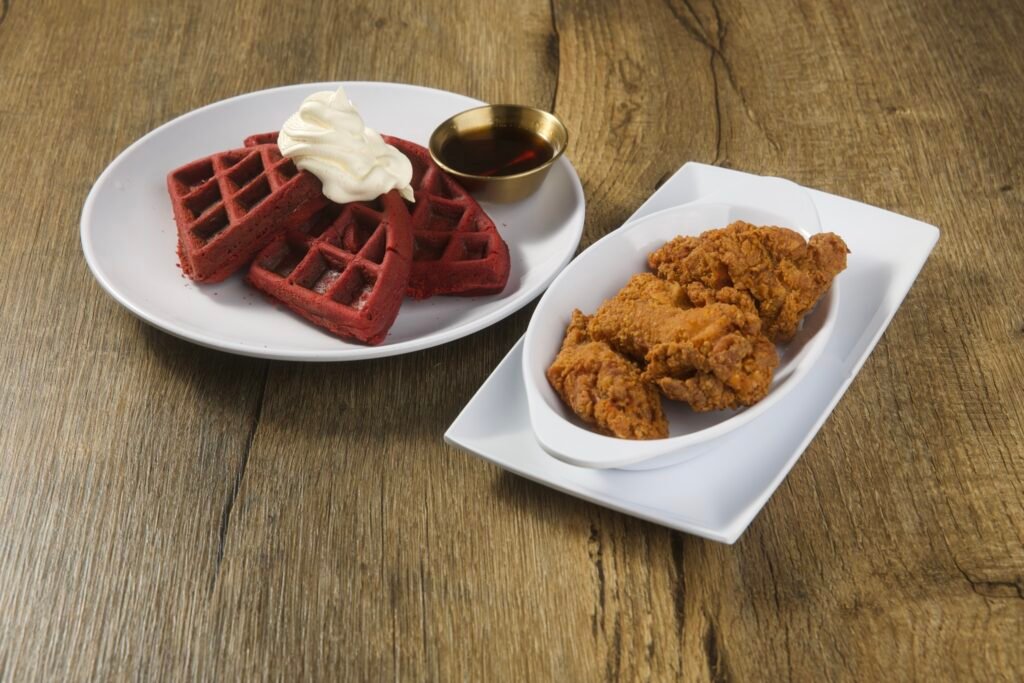 Fried chicken with red velvet waffles and syrup, fried food photography for a restaurant menu