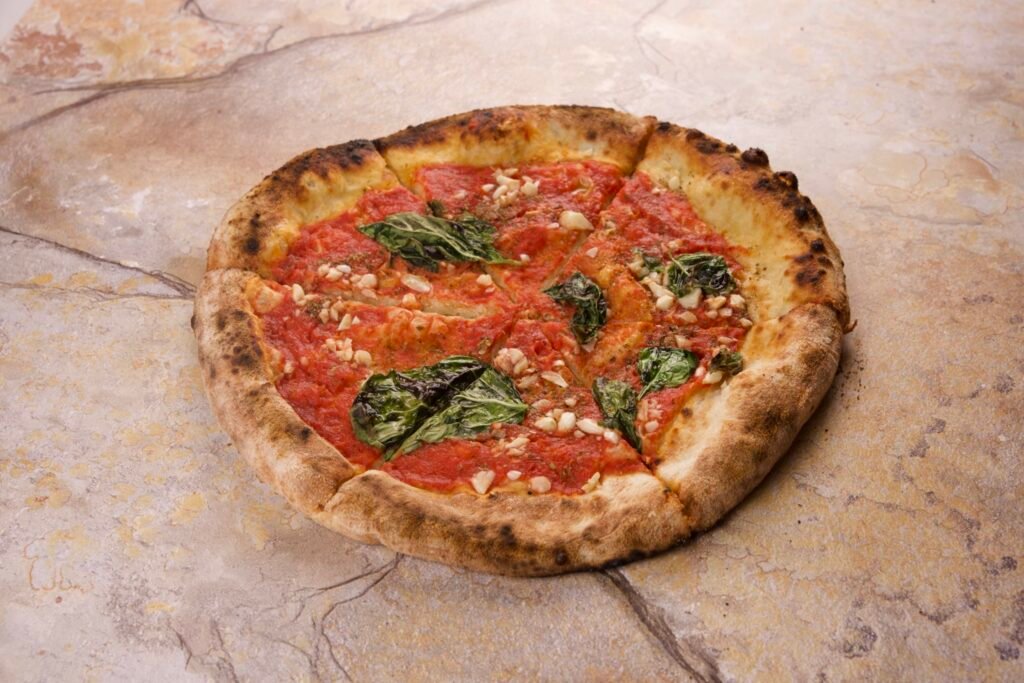 Tomato pie with basil on a stone surface, pizza photography for a pizzeria menu